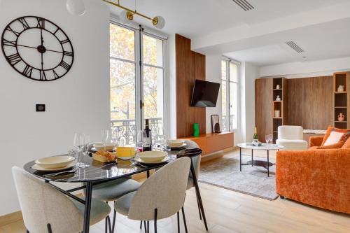 une salle à manger et un salon avec une horloge murale dans l'établissement Bluestay 292 - Superbe appartement à Paris 17, à Paris