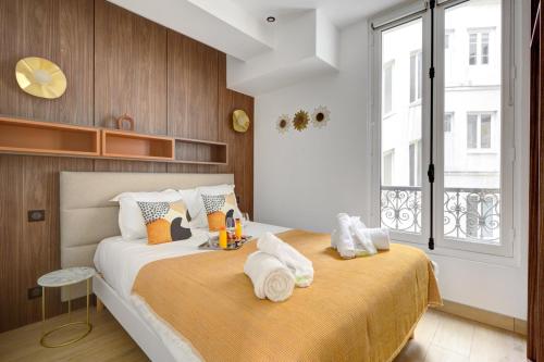 une chambre avec un grand lit avec des serviettes dessus dans l'établissement Bluestay 292 - Superbe appartement à Paris 17, à Paris