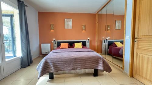 une chambre avec un lit et un grand miroir dans l'établissement villa rayons de soleil, à Magalas