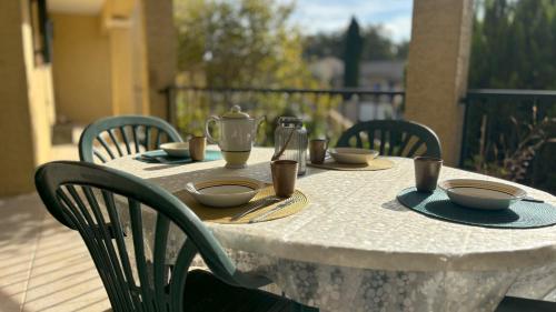 une table avec un chiffon de table blanc, des bols et des tasses dans l'établissement villa rayons de soleil, à Magalas