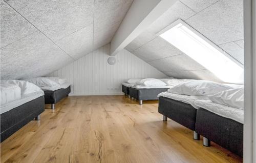a attic room with three beds and a window at 9 Bedroom Beautiful Home In Sydals in Sarup