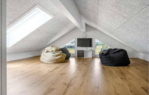 a attic room with a skylight and a tv at 9 Bedroom Beautiful Home In Sydals in Sarup