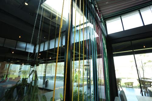 a room with a large window with tables and chairs at Navela Hotel & Convention in Ratchaburi