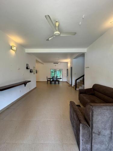 a living room with a couch and a ceiling fan at Theeram Riverside Holiday Home in Māla
