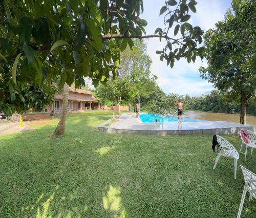 a man standing next to a swimming pool in a yard at Theeram Riverside Holiday Home in Māla