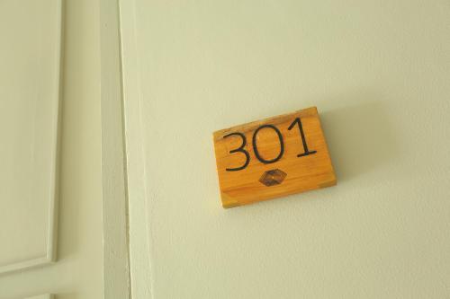 a wooden sign on a door with the number at Navela Hotel & Convention in Ratchaburi