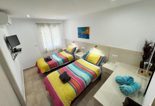 une chambre avec deux lits et une télévision dans l'établissement Casa Los Pinos, à Benissa