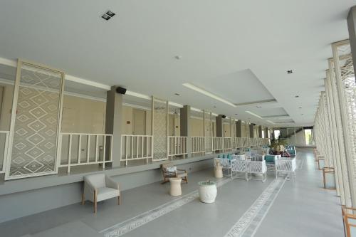a hallway with chairs and tables in a building at Navela Hotel & Convention in Ratchaburi