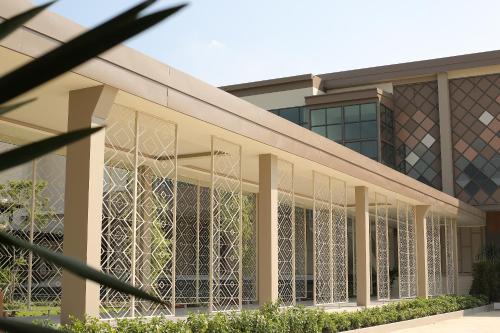 an exterior view of a building with intricate glass windows at Navela Hotel & Convention in Ratchaburi