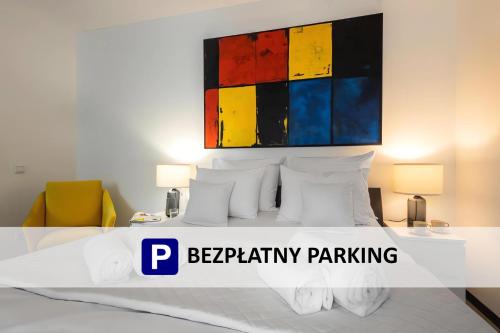 a bedroom with a bed with a painting above it at Aparthotel Solskiego Wrocław in Wrocław