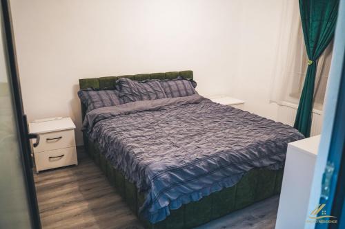 a bedroom with a bed with a purple comforter at Palko Residence in Ocna-Mureşului