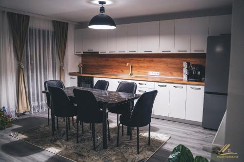 a kitchen with a dining room table and chairs at Palko Residence in Ocna-Mureşului