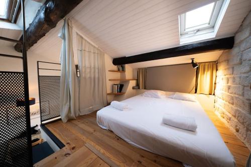 une chambre avec un grand lit blanc et une fenêtre dans l'établissement L'Atelier 29, beau T2 cosy and chill, à Montpellier