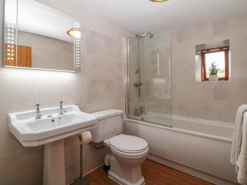une salle de bain avec un lavabo, des toilettes et une douche dans l'établissement Brook Cottage, à Hayfield