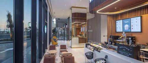 a restaurant with tables and chairs in a store at Hampton By Hilton Kuwait Salmiya in Kuwait
