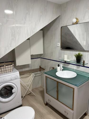 a bathroom with a washing machine and a sink at Casa rural ValenTina in Almonacid de Toledo