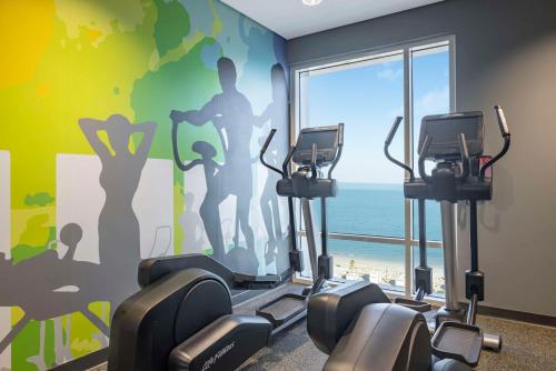 a gym with a wall with a mural of a beach at Hampton By Hilton Kuwait Salmiya in Kuwait