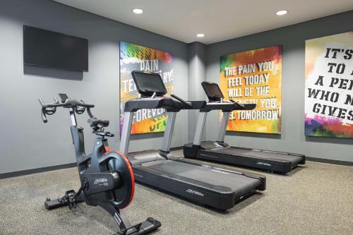 a gym with two exercise bikes and two posters at Hampton By Hilton Kuwait Salmiya in Kuwait