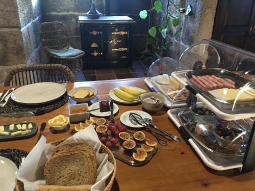 a table with a bunch of food on it at The Hideaway at Quinta de Moçamedes - Suites & Apartments in Vouzela