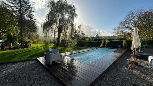 a swimming pool in a garden with an umbrella at Boutique Hotel Le Faucon in Valkenburg