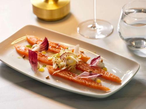 a plate of food with carrots on a table at Domaine du Liziec Vannes - MGallery Collection in Vannes