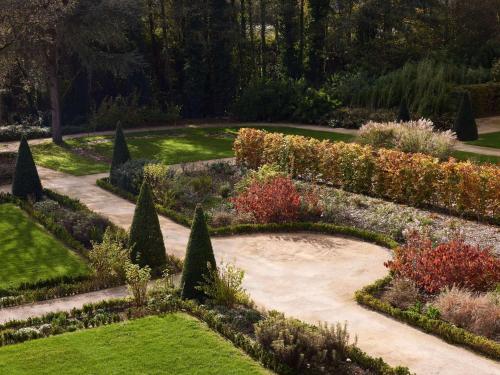 a garden with a stone path and plants at Domaine du Liziec Vannes - MGallery Collection in Vannes
