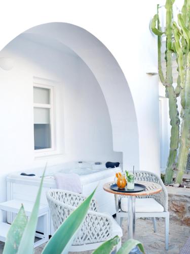 a room with a table and chairs and cactus at Stelia Mare Boutique Hotel in Naousa