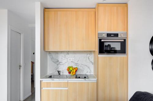 une cuisine avec un évier et un micro-ondes dans l'établissement 153 Suite Mylene - Superbe Appartement à Paris, à Paris
