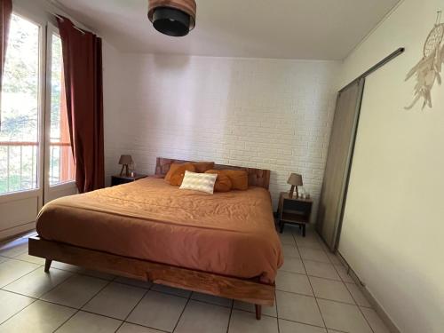 une chambre avec un lit et une grande fenêtre dans l'établissement Calme, vue st Victoire, proche centre ville avec parking, à Aix-en-Provence