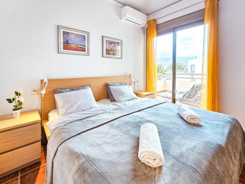a bedroom with a large bed and a large window at La Tejita - Family Apartment Home in La Mareta