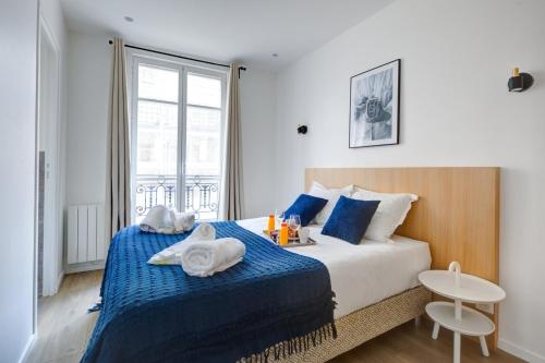une chambre avec un lit avec des serviettes dessus dans l'établissement 159 Suite Margot - Superbe Appartement à Paris, à Paris
