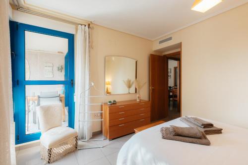 a bedroom with a bed and a chair and a window at RESORT BEACH VALENCIA in Valencia