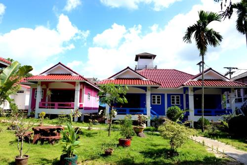 a row of houses with palm trees in the yard at New Sunrise Village in Mae Nam
