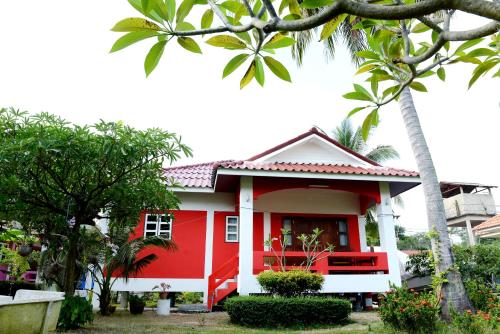 a red and white house with palm trees at New Sunrise Village in Mae Nam
