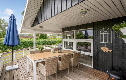 a patio with a table and chairs and an umbrella at Holiday Home Slåenvænget Hejls X Denmark in Hejls