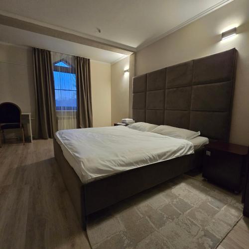 a bedroom with a large bed and a window at Phorto Bella in Ustʼ-Kamenogorsk