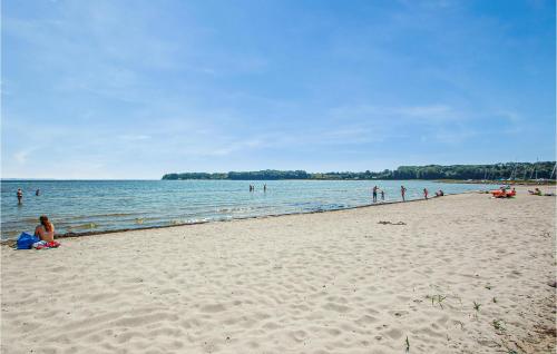 a group of people on a beach near the water at Holiday Home Slåenvænget Hejls X Denmark in Hejls