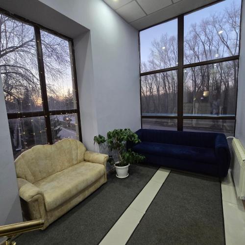 a living room with a couch and a large window at Phorto Bella in Ustʼ-Kamenogorsk