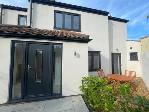 une maison avec des portes noires et une terrasse dans l'établissement Seaside Retreat - Sleeps 5 garden & parking, à Cromer