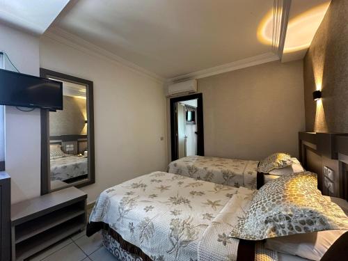 a hotel room with two beds and a mirror at Monte Carlo Hotel in Alanya