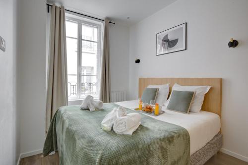 une chambre avec un lit avec des serviettes dessus dans l'établissement 154 Suite Phil - Superbe Appartement à Paris., à Paris