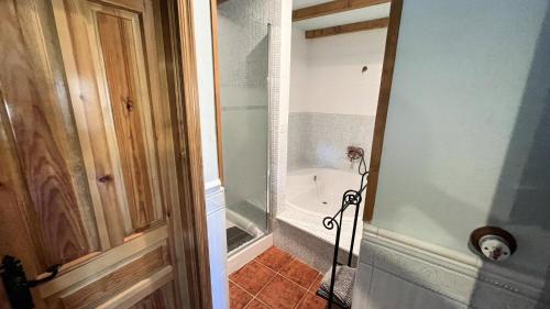 a bathroom with a bath tub and a toilet at La Puerta de Gredos in San Martín del Pimpollar