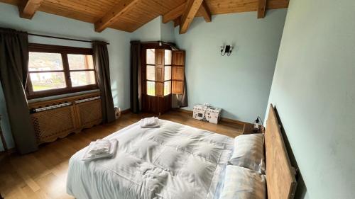 a bedroom with a large bed in a room with a window at La Puerta de Gredos in San Martín del Pimpollar