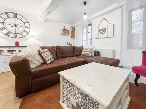 a living room with a brown couch and a table at Loft cosy au cœur de Vence in Vence