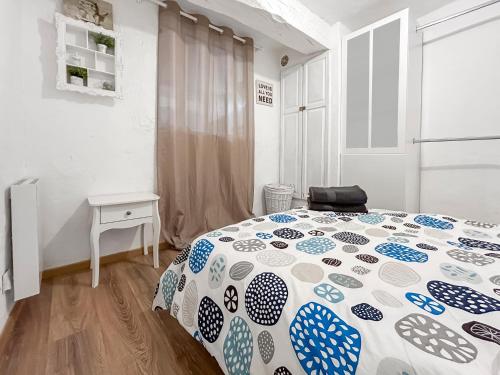 a bedroom with a bed with a blue and white comforter at Loft cosy au cœur de Vence in Vence