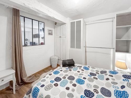 a bedroom with a bed with a blue and white comforter at Loft cosy au cœur de Vence in Vence