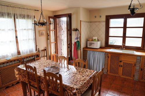 a dining room with a table and a kitchen at La Puerta de Gredos in San Martín del Pimpollar