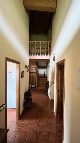 a hallway of a house with a tile floor and stairs at La Puerta de Gredos in San Martín del Pimpollar
