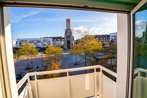a window view of a clock tower from a balcony at Breeze Hotel in Calais