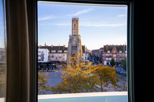 a view of a clock tower from a window at Breeze Hotel in Calais